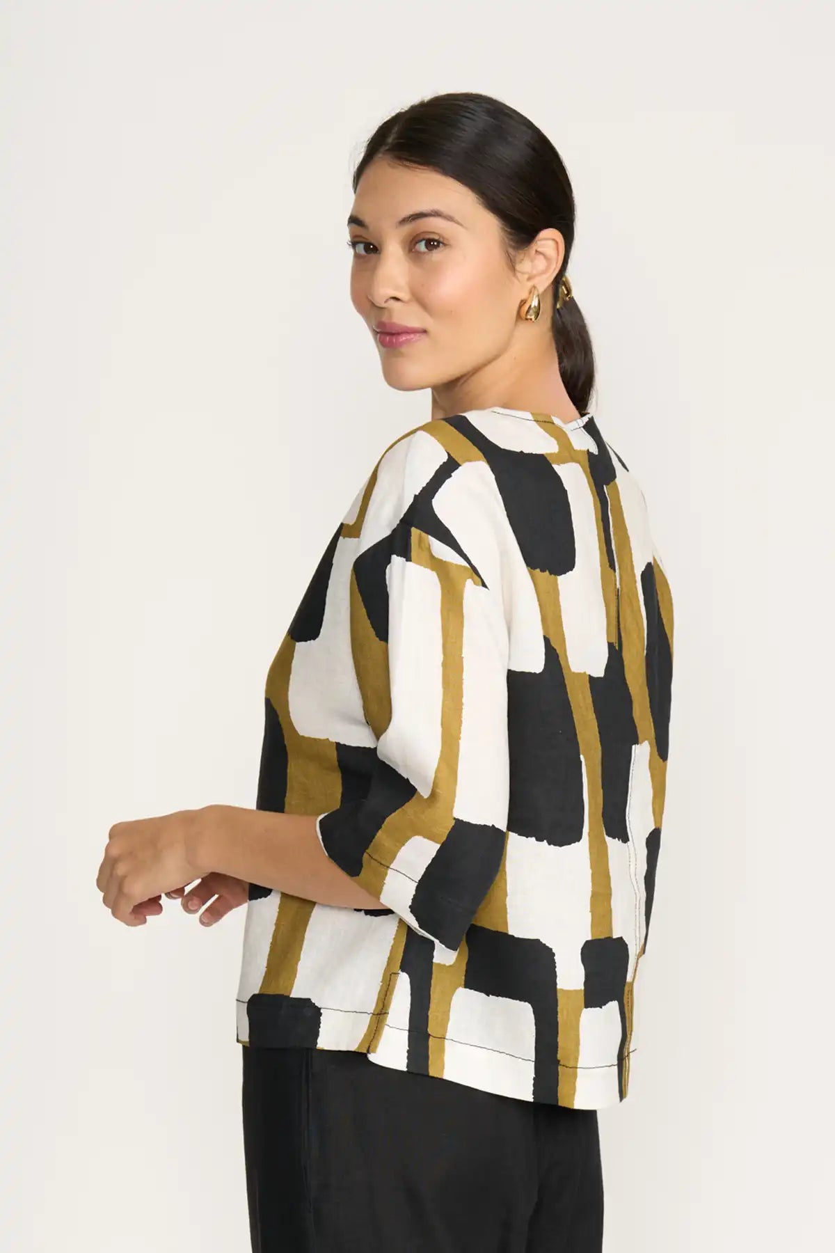 Woman wearing a Foil Looking Sharp Top in Art Box Print on a white background back 3/4 view