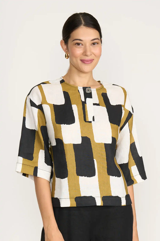 Woman wearing a Foil Looking Sharp Top in Art Box Print with geometric design on a white background