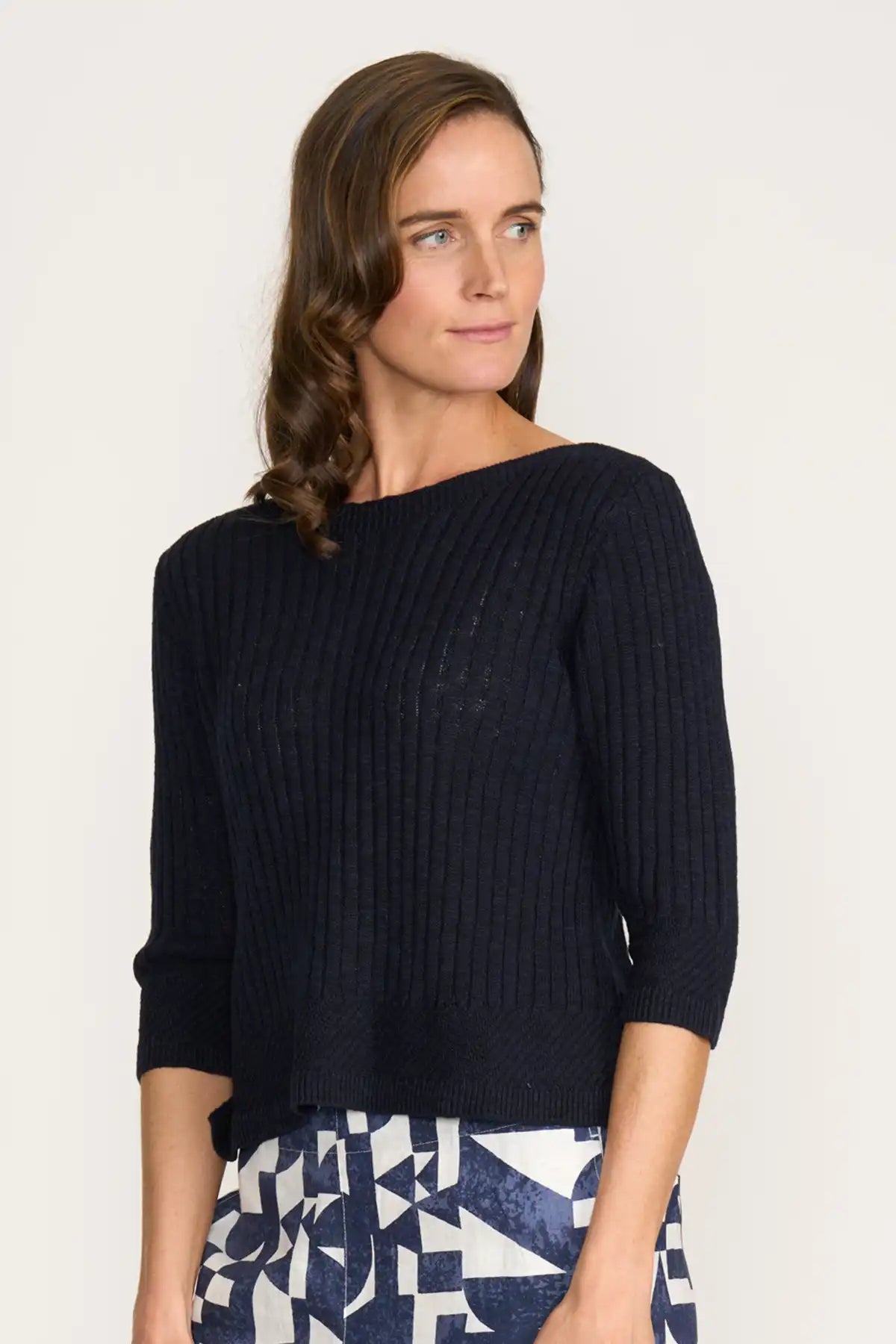 Woman wearing a Foil Nitty Gritty Sweater in True Navy with a white background side view