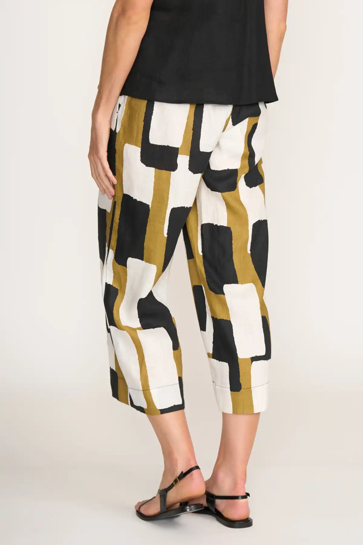 Person wearing a black top and Foil It's Only Natural Linen Pants in Art Box Print  on a white background back view