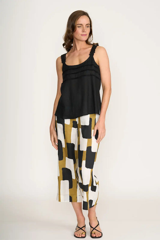 Woman wearing a black sleeveless top and Foil It's Only Natural Linen Pants in Art Box Print on a white background
