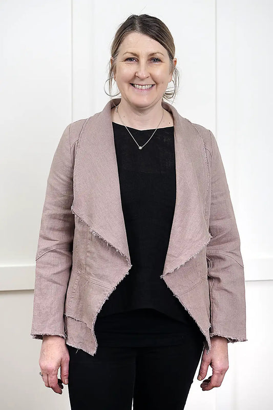 woman wearing a Francesca Linen Jacket in Mushroom with black tee and jeans against a white wall standing front on