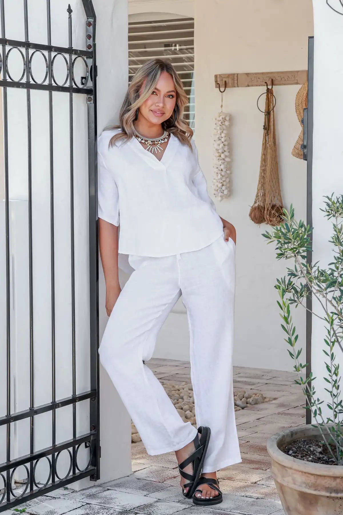 Woman in a Gemma Italian Linen White Top standing in a home setting with decor elements.