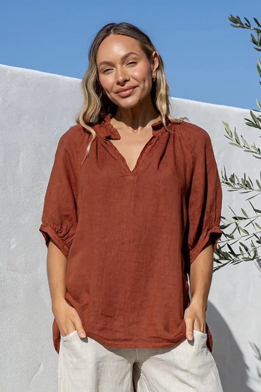 Woman wearing a Giulia Italian Linen Coco Top with a white background and greenery