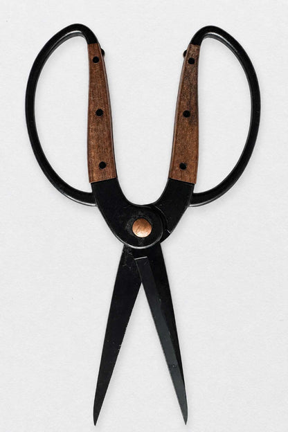 A pair of large black-handled herb and garden scissors with brown wood-grain handles and a brass pivot screw, shown against a plain light gray background.