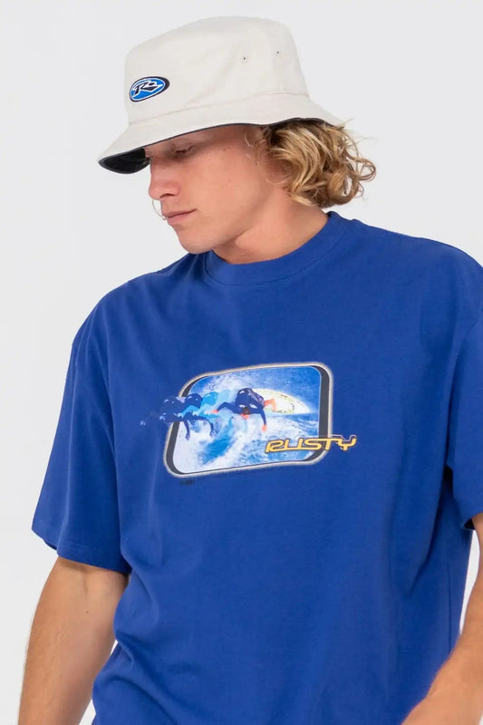 Person wearing a blue t-shirt with a graphic design and a Rusty Kick Flip Reversible Bucket Hat in Oatmeal on a plain background