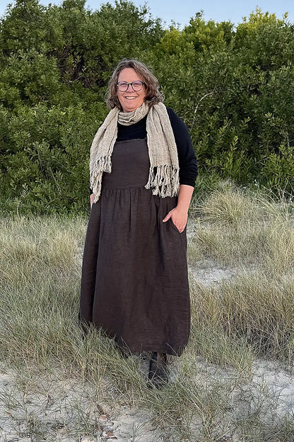 women standing at beach wearing a linen pinafore and linen scarf in natural colours
