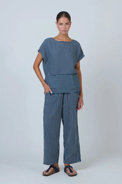 Woman wearing a blue and white striped outfit on a plain background