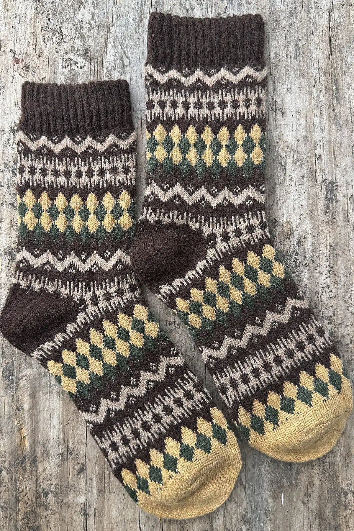 Pair of knitted socks with a pattern on a wooden surface