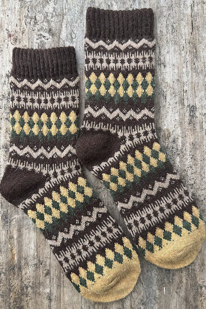 Pair of knitted socks with a pattern on a wooden surface