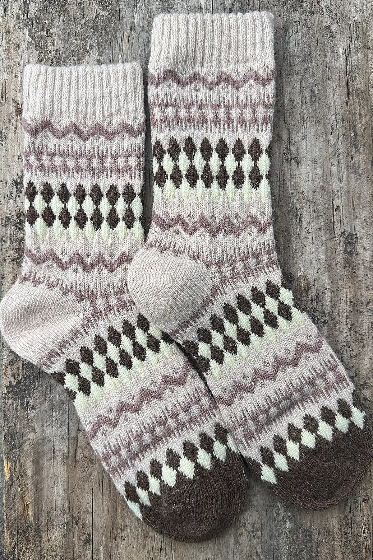 Pair of knitted socks with a pattern on a wooden surface