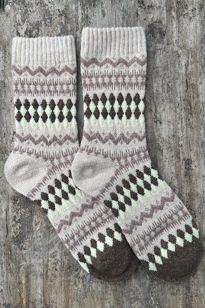 Pair of knitted socks with a pattern on a wooden surface