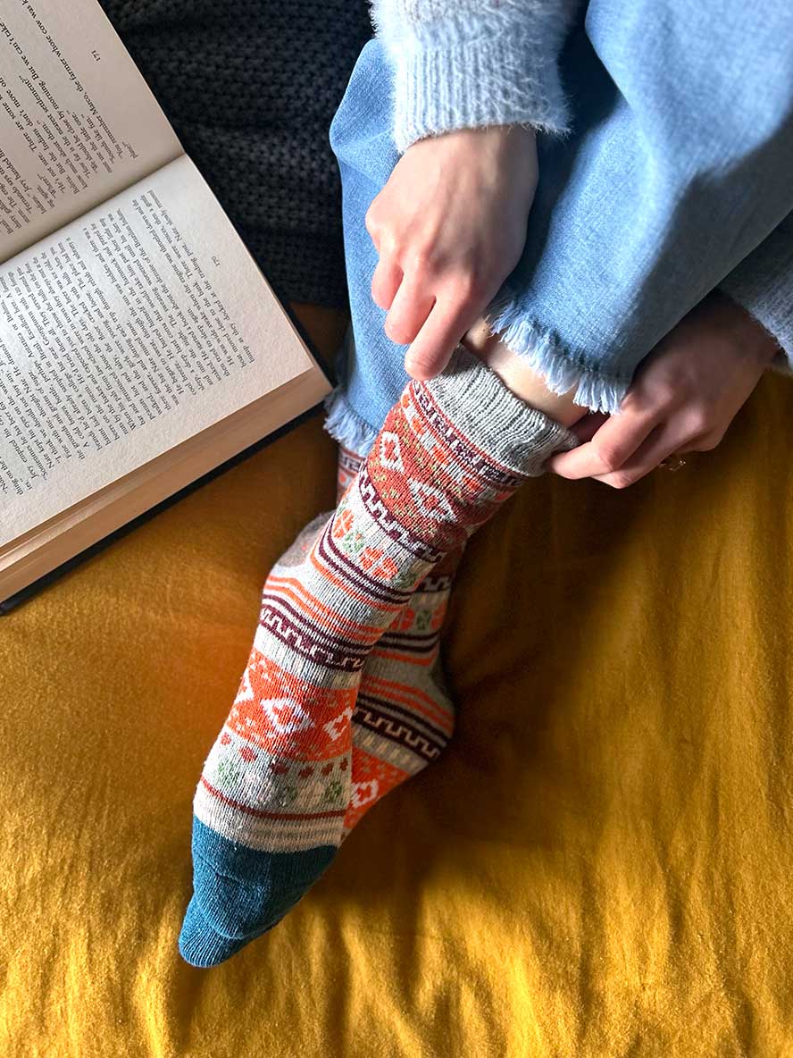 Grey Nordic Style Socks on the bed with a book
