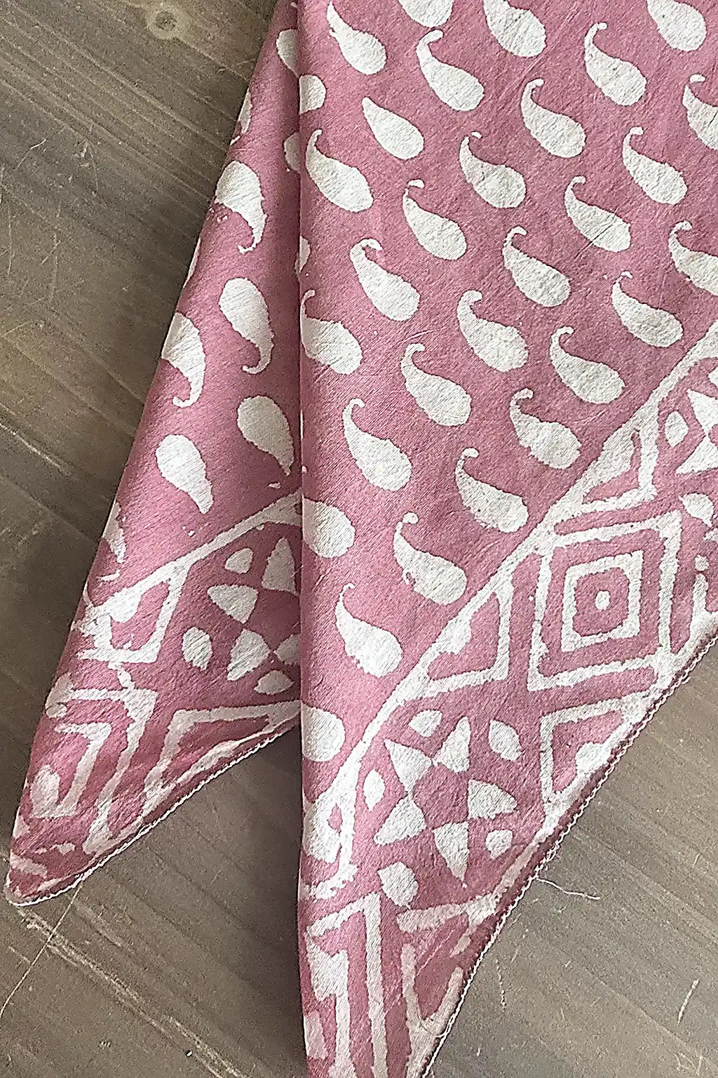 pink cotton fabric scarf with a white patten on a wooden table
