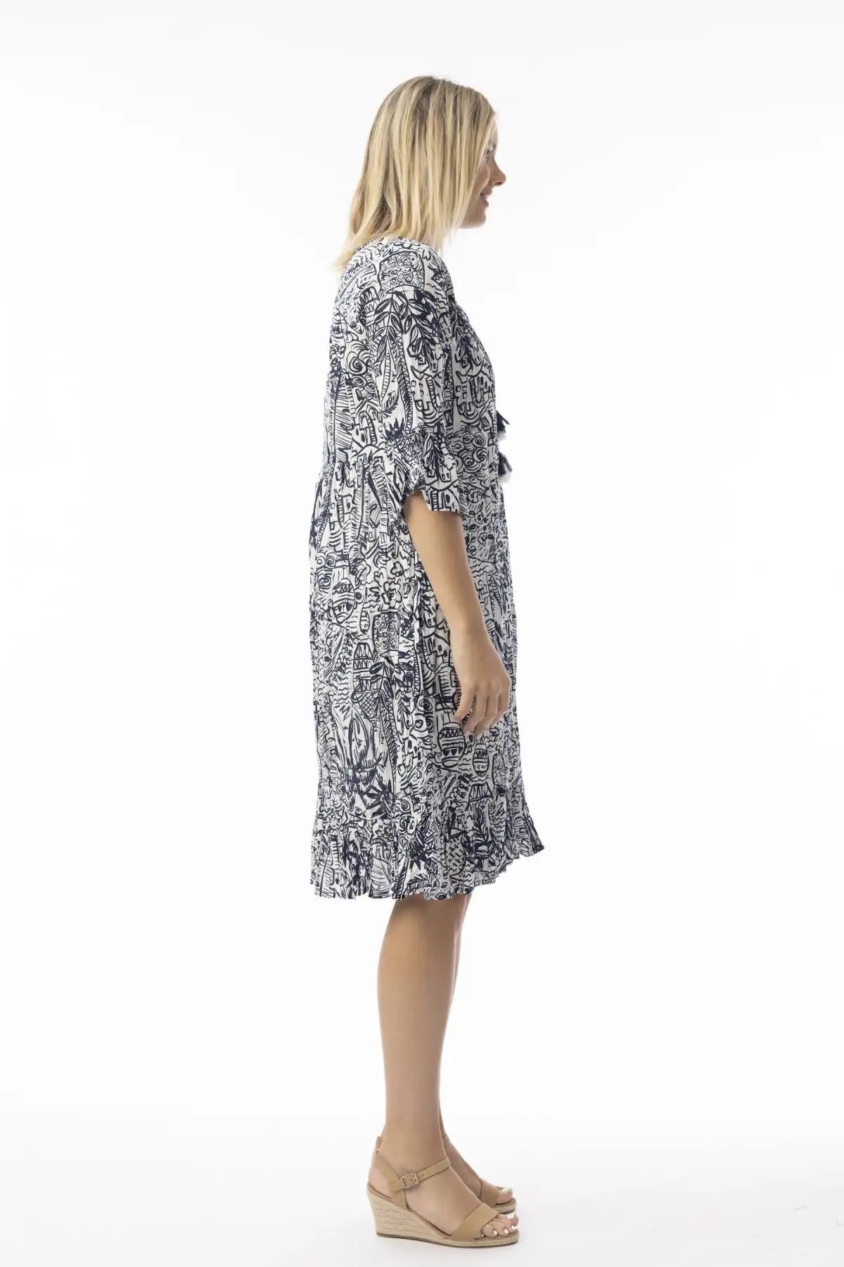 Woman wearing a  Orientique Aksharay Navy Dress standing side on against a white background