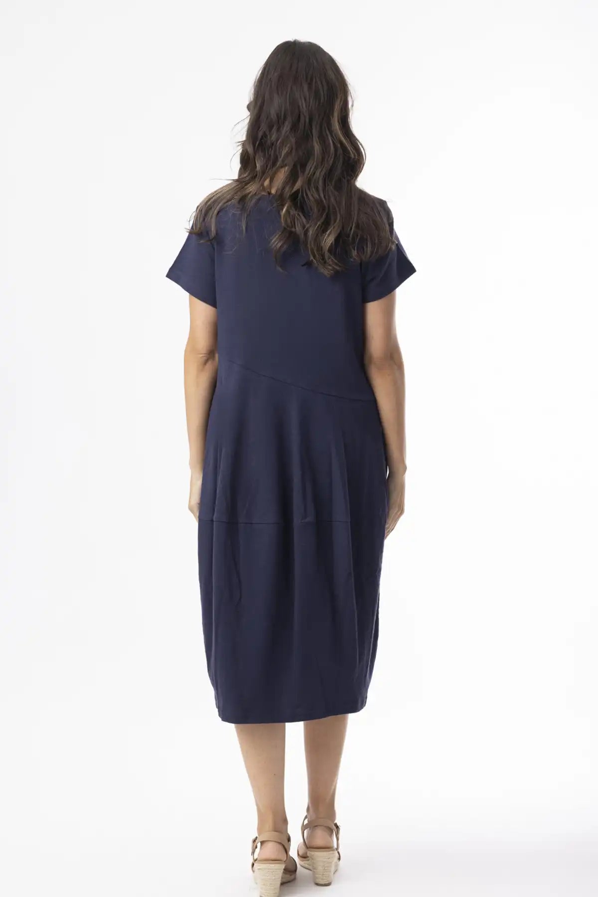 Woman wearing a Orientique Essentials Organic Cotton Bubble Dress – Navy from behind on a white background