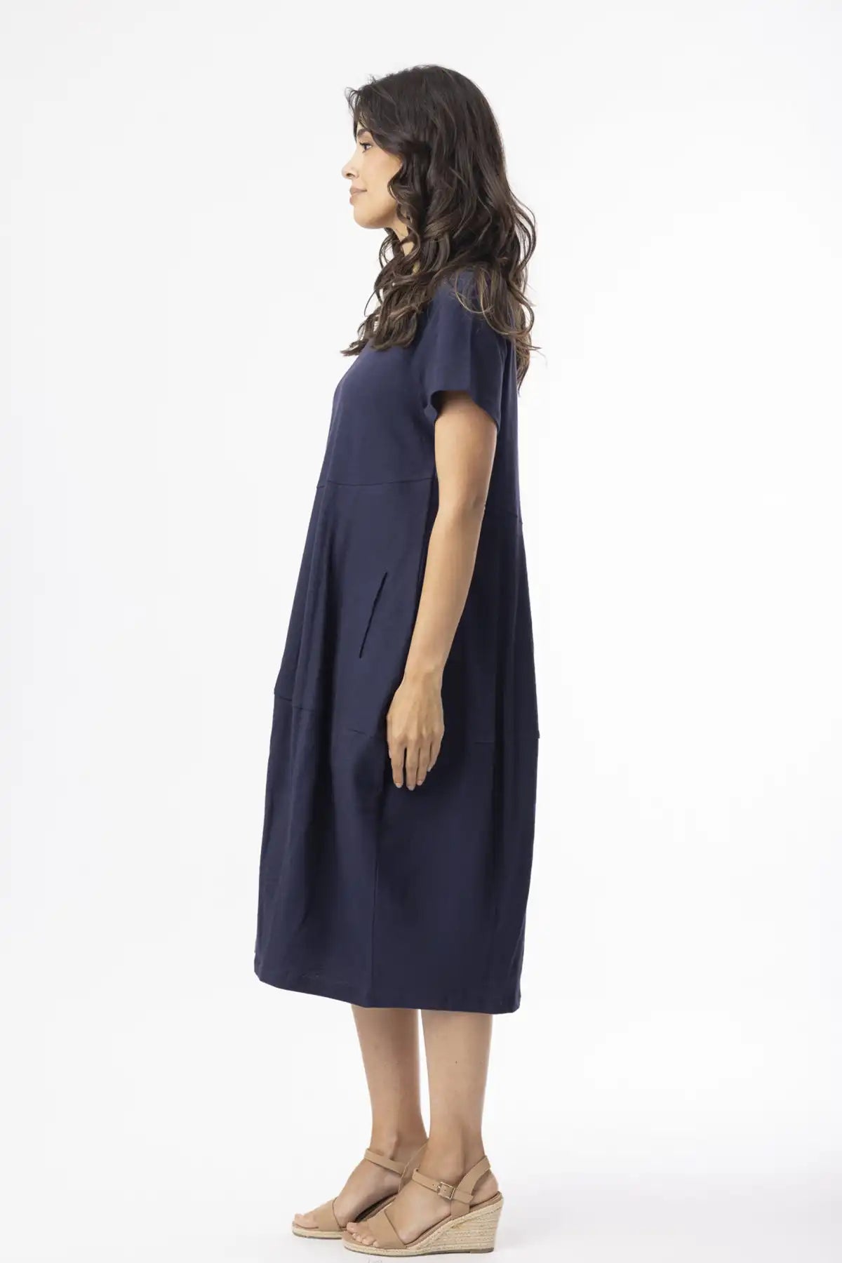 Woman wearing a Orientique Essentials Organic Cotton Bubble Dress – Navy side view on a white background