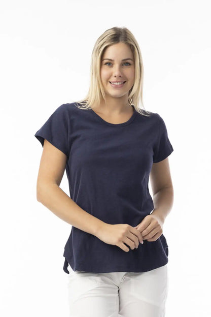 Woman wearing a Orientique Essentials Organic Cotton Crew Tee in Navy and white pants on a white background