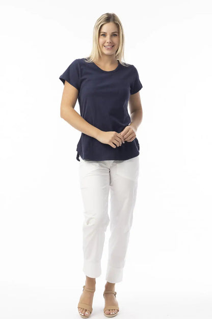Woman wearing a Orientique Essentials Organic Cotton Crew Tee in Navy and white pants on a white background