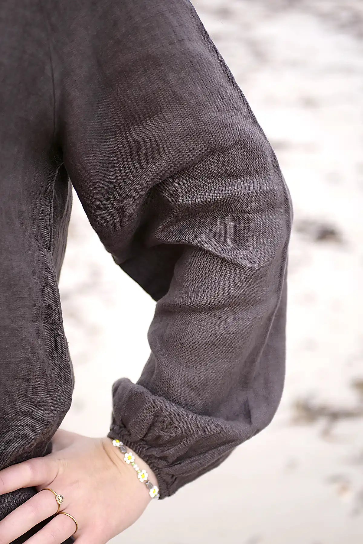Close-up of a person wearing a brown long-sleeve garment with a blurred background