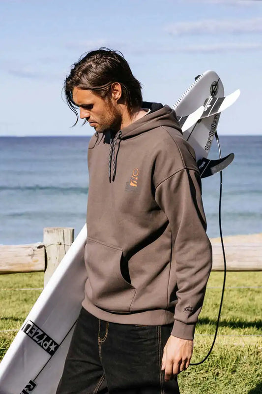 Rip Curl Anti Series Search Stack Hood in Rock feature image with man carrying surf board