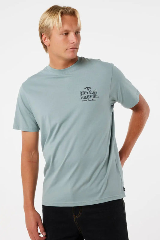 Man wearing a light blue t-shirt with a logo on a white background