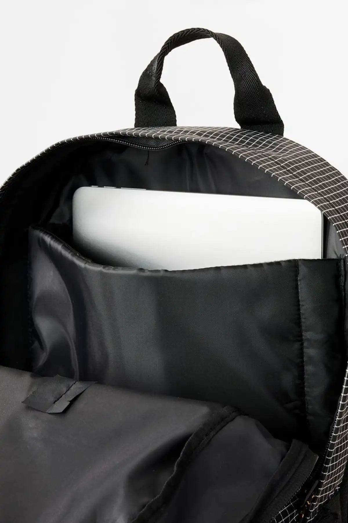  Rip Curl  Black backpack with a laptop inside on a white background