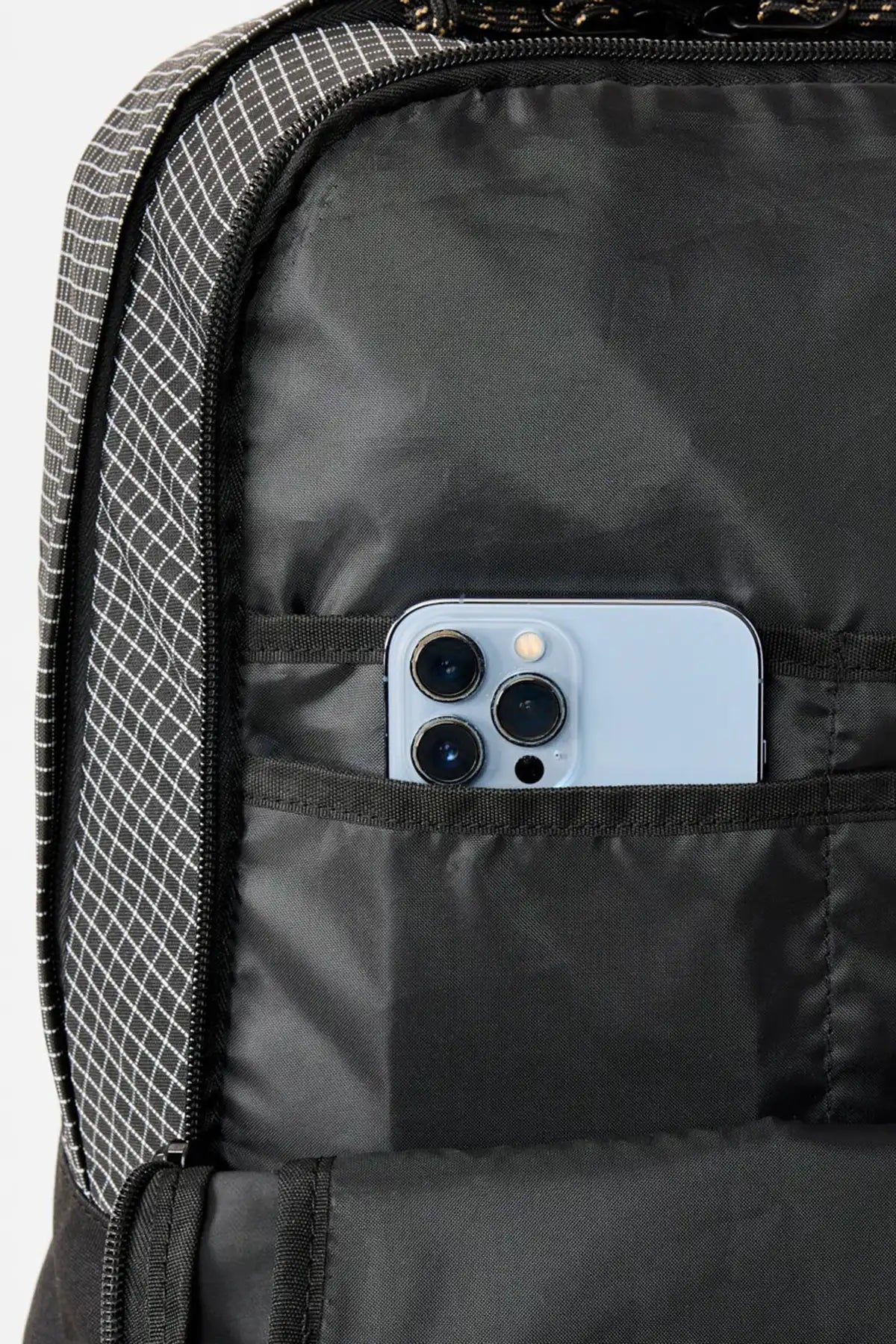  Rip Curl  Black backpack with a pocket containing a smartphone