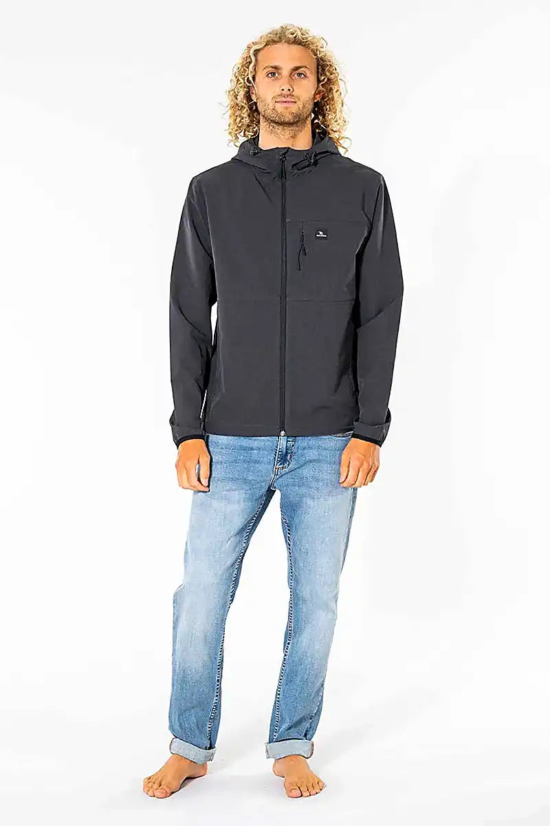 Man wearing Rip Curl Elite Anti-Series Zip Through Jacket and blue jeans on a white background full model view front