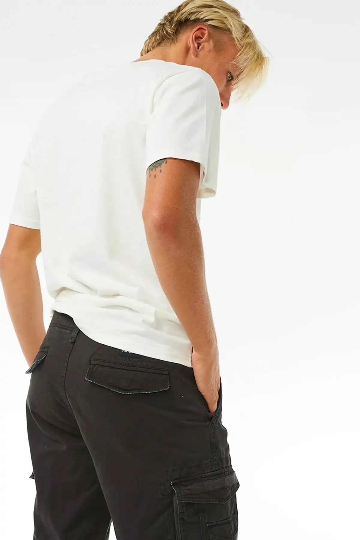 Person wearing a white t-shirt and Rip Curl Washed Black cargo pants on a white background