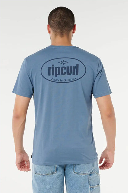 Person wearing a blue Rip Curl t-shirt with a logo on the back against a white background