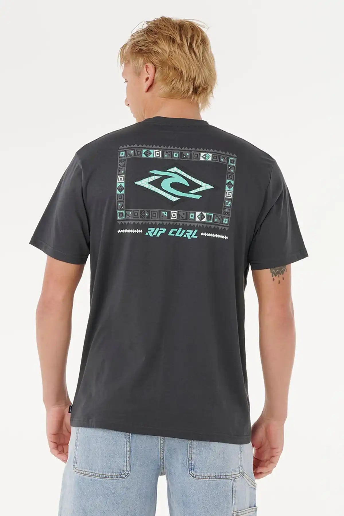 Person wearing a washed black Rip Curl t-shirt with branding on the back against a white background