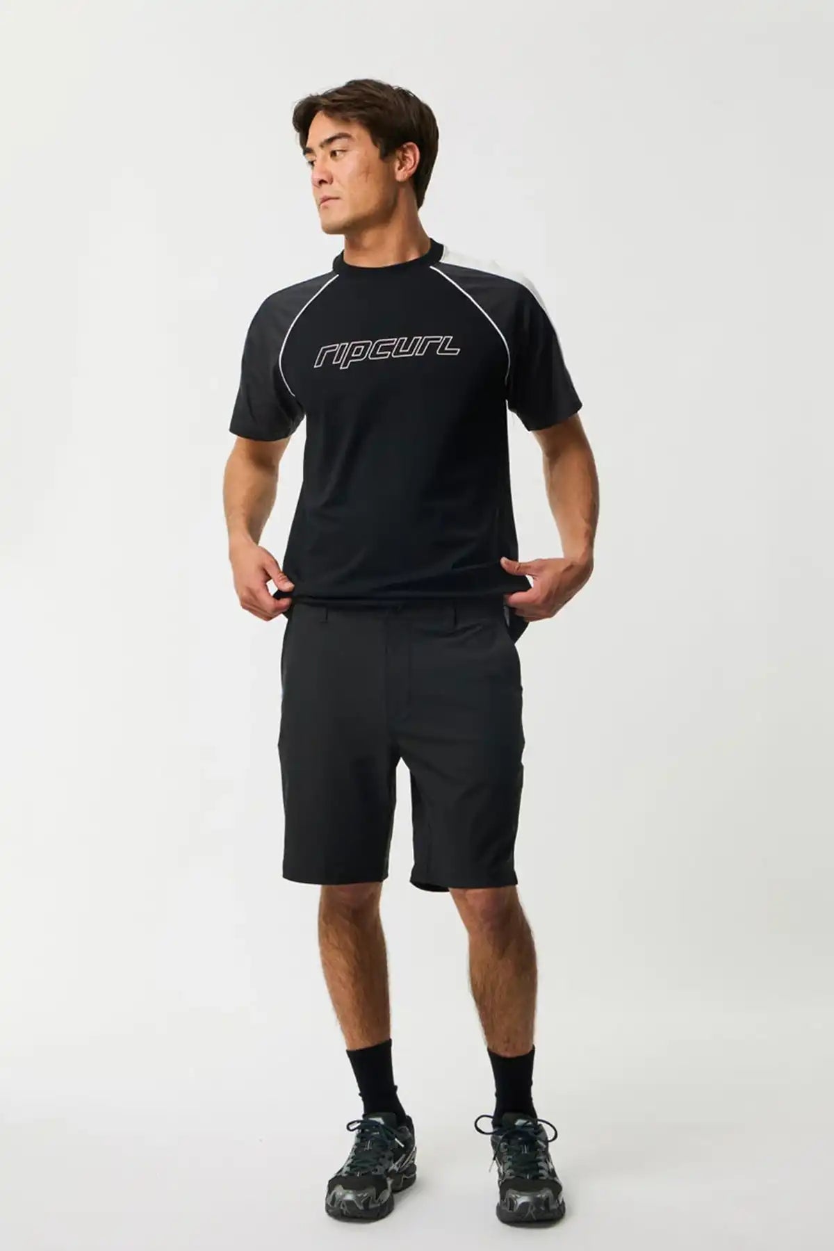 Person wearing a black athletic outfit with a Rip Curl brand logo on a white background