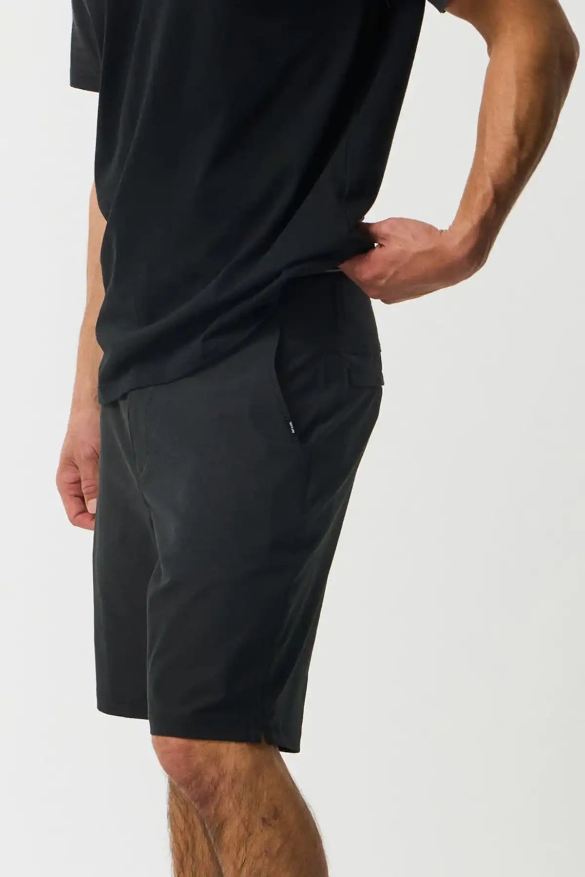 Person wearing black shorts and a black t-shirt on a white background
