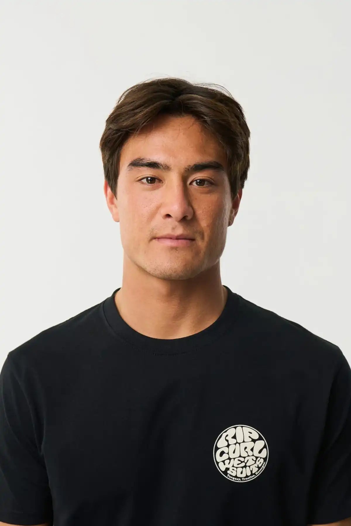 Man wearing a black t-shirt with a Rip Curl Wettie logo on a white background