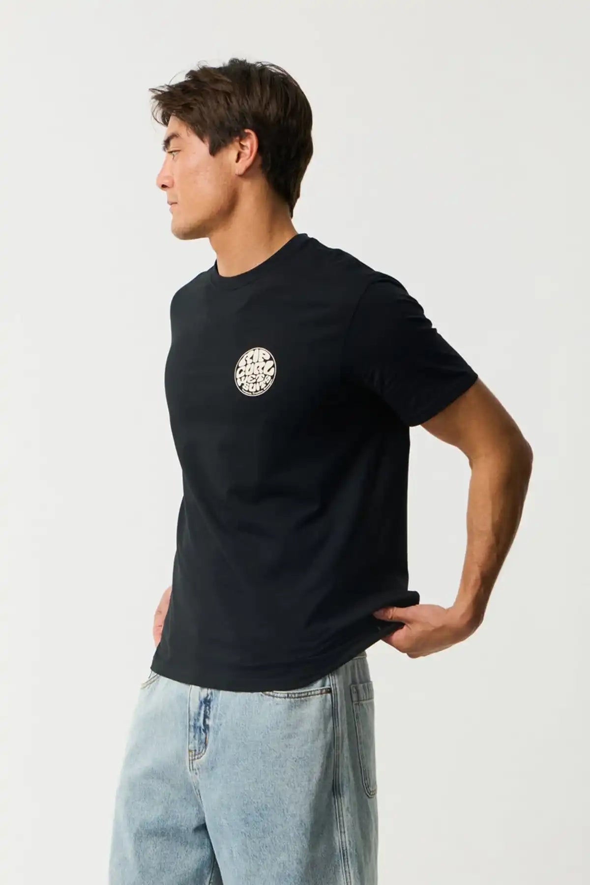 Man wearing a black t-shirt with a white Rip Curl Wettie logo on a plain background