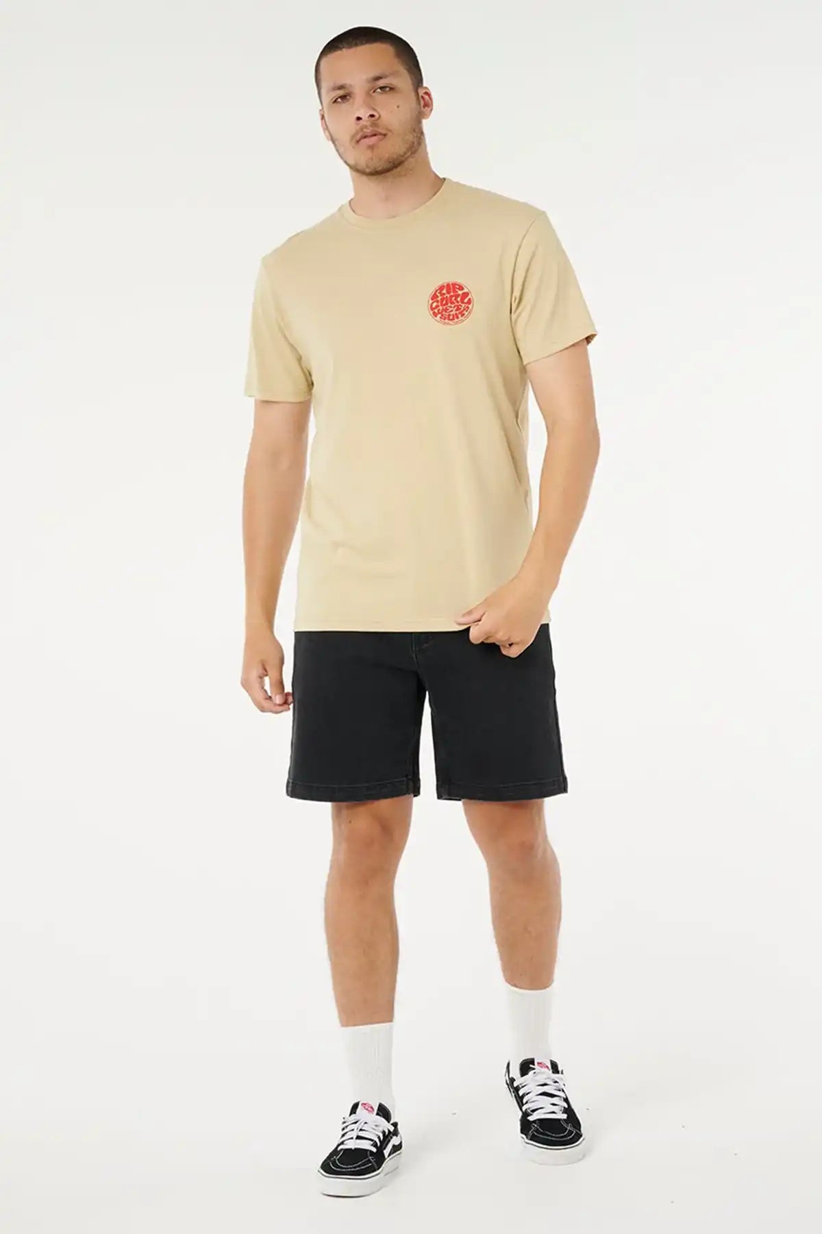 Man wearing a khaki sand t-shirt with a red Rip Curl Wettie logo and black shorts on a white background