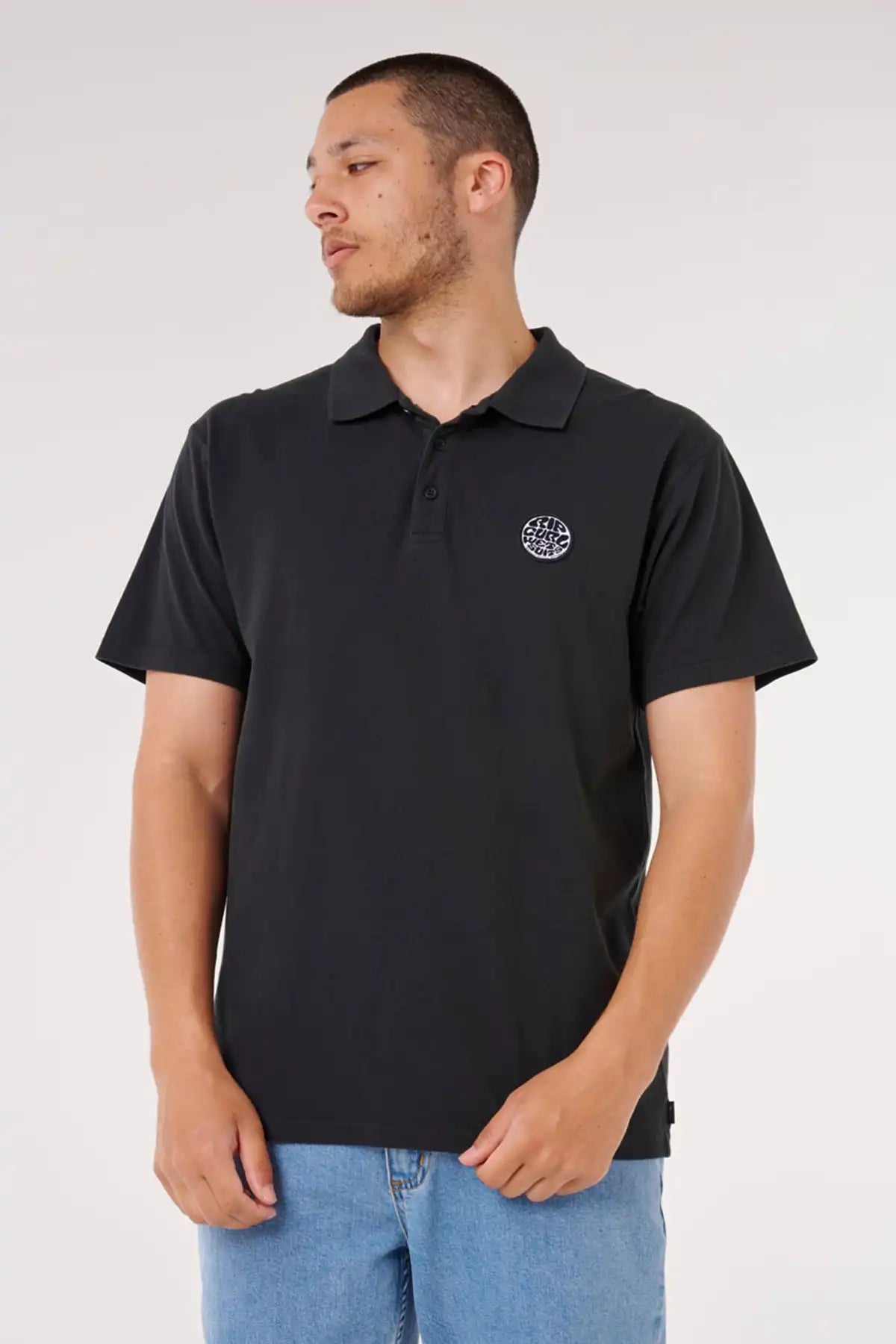 Man wearing a black polo shirt with a Rip Curl logo on a white background