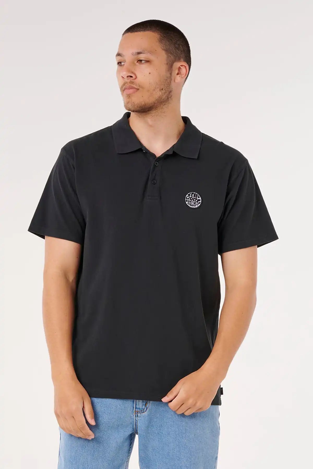 Man wearing a black polo shirt with a Rip Curl logo on a white background