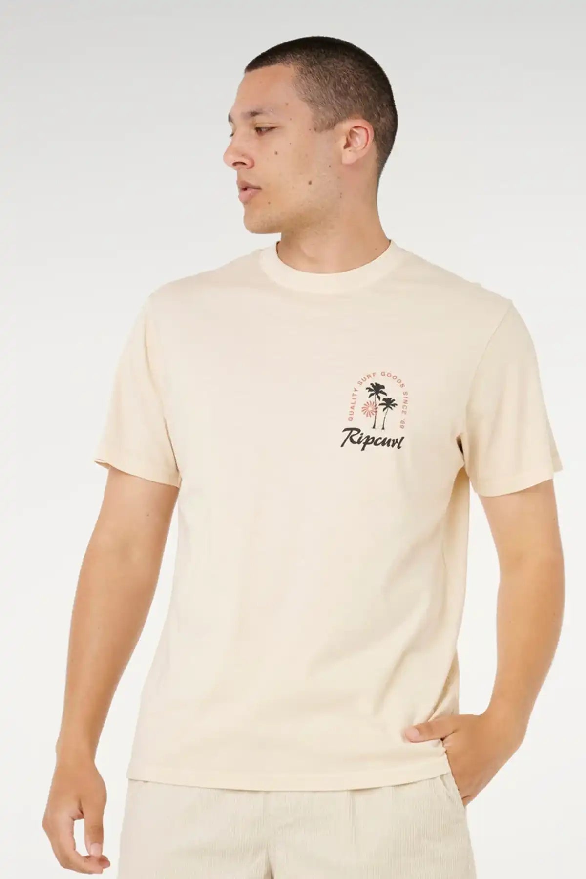 Man wearing a beige t-shirt with a palm tree design and 'Rip Curl' logo on a white background