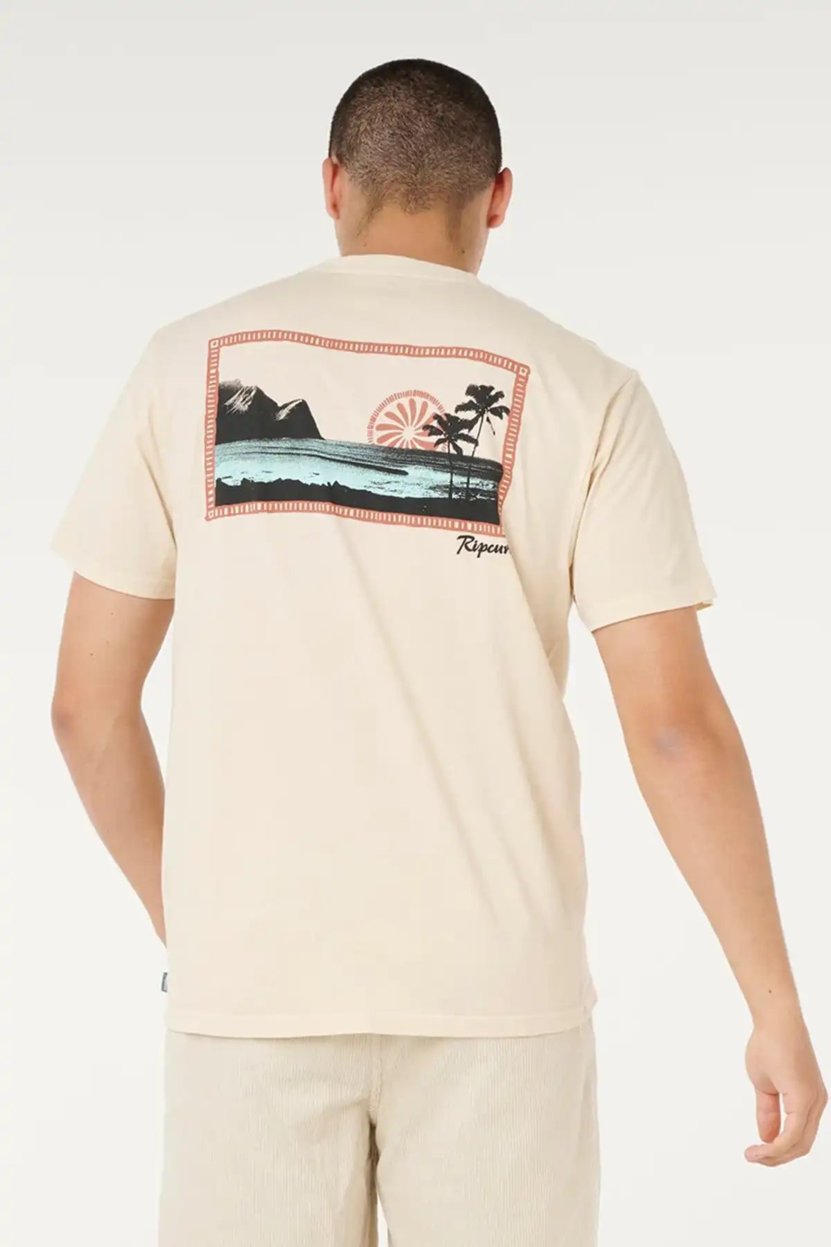 Man wearing a beige t-shirt with a graphic design on the back, standing against a white background