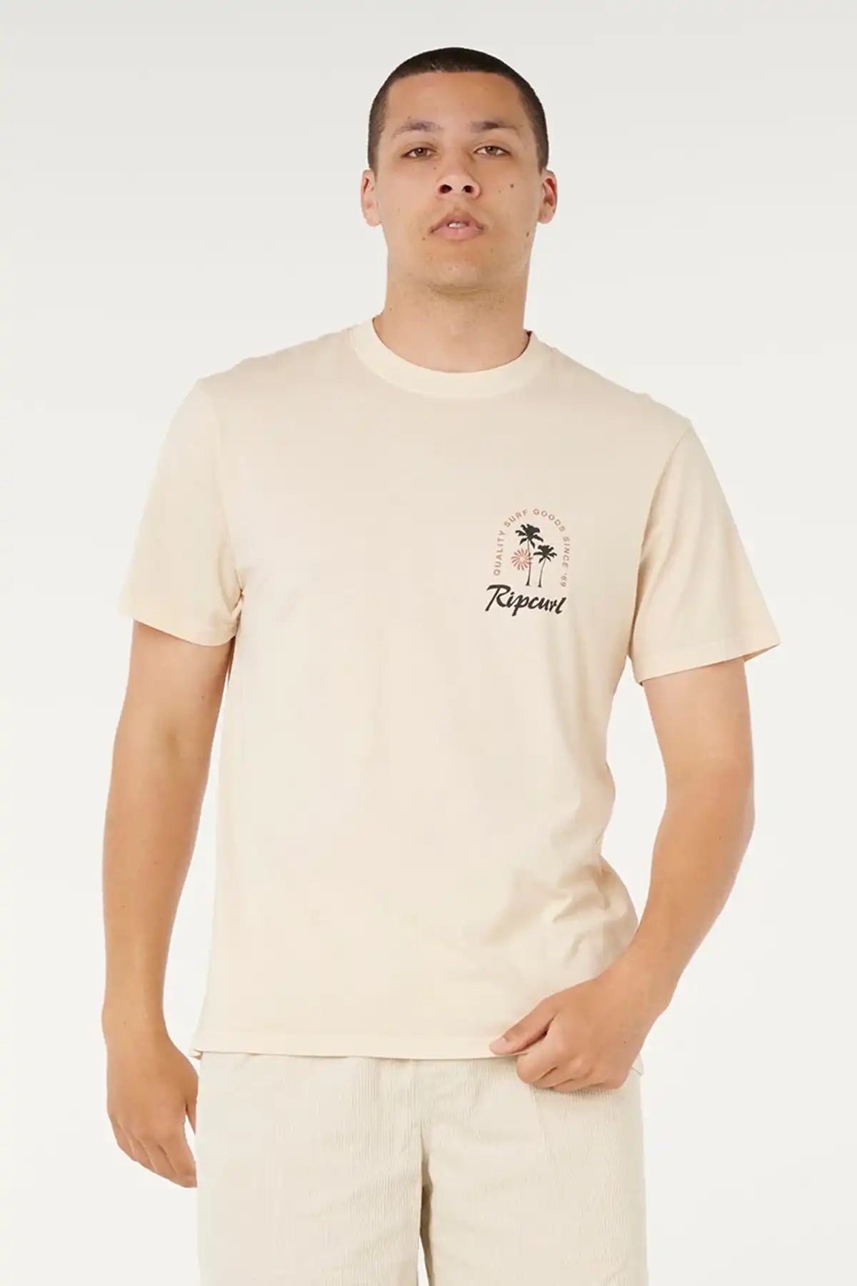 Man wearing a beige t-shirt with a small graphic and text on a white background