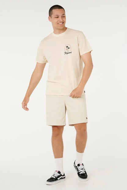 Person wearing a beige t-shirt and shorts set with a brand logo on a white background
