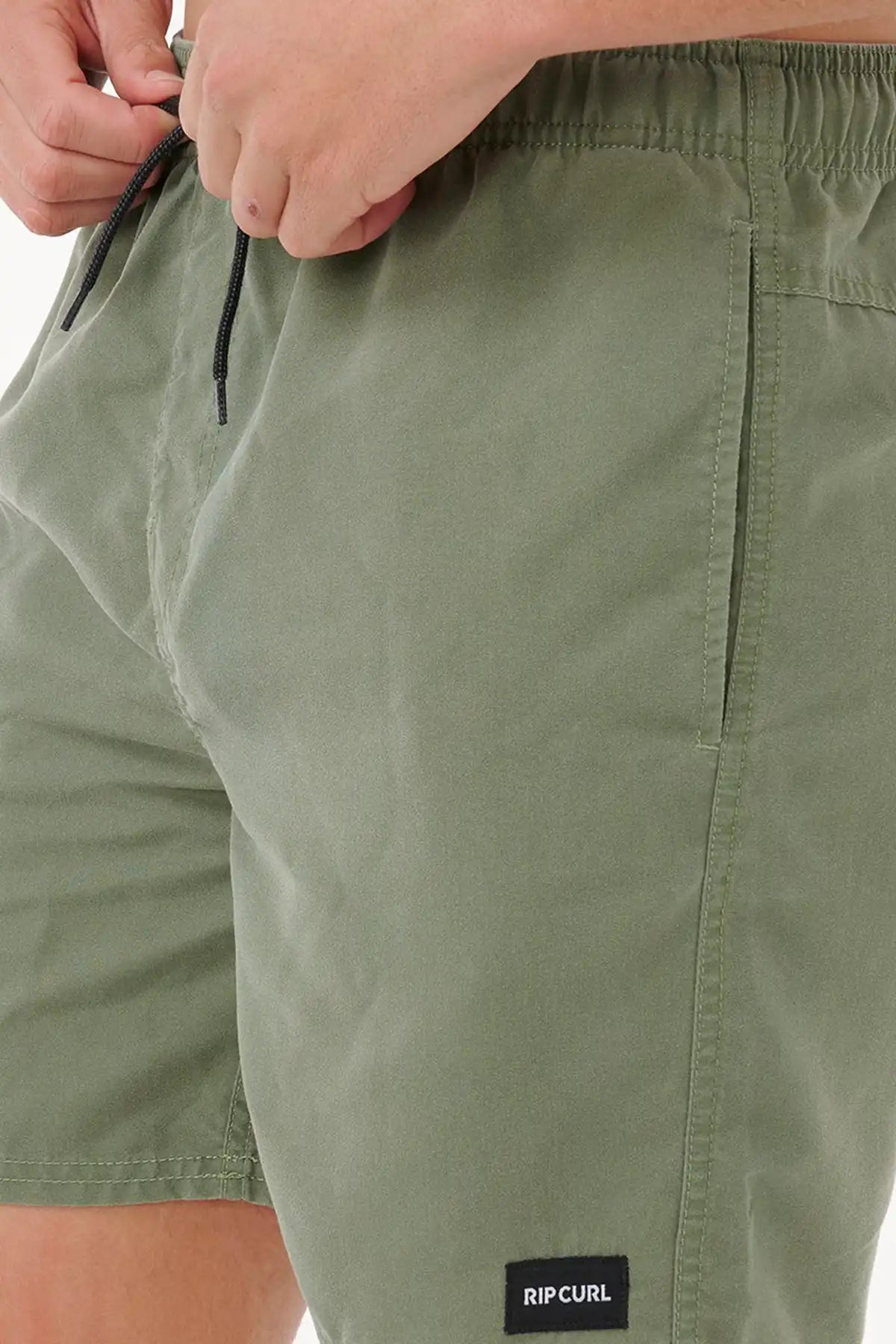 Close-up of green shorts with a Rip Curl logo on a white background