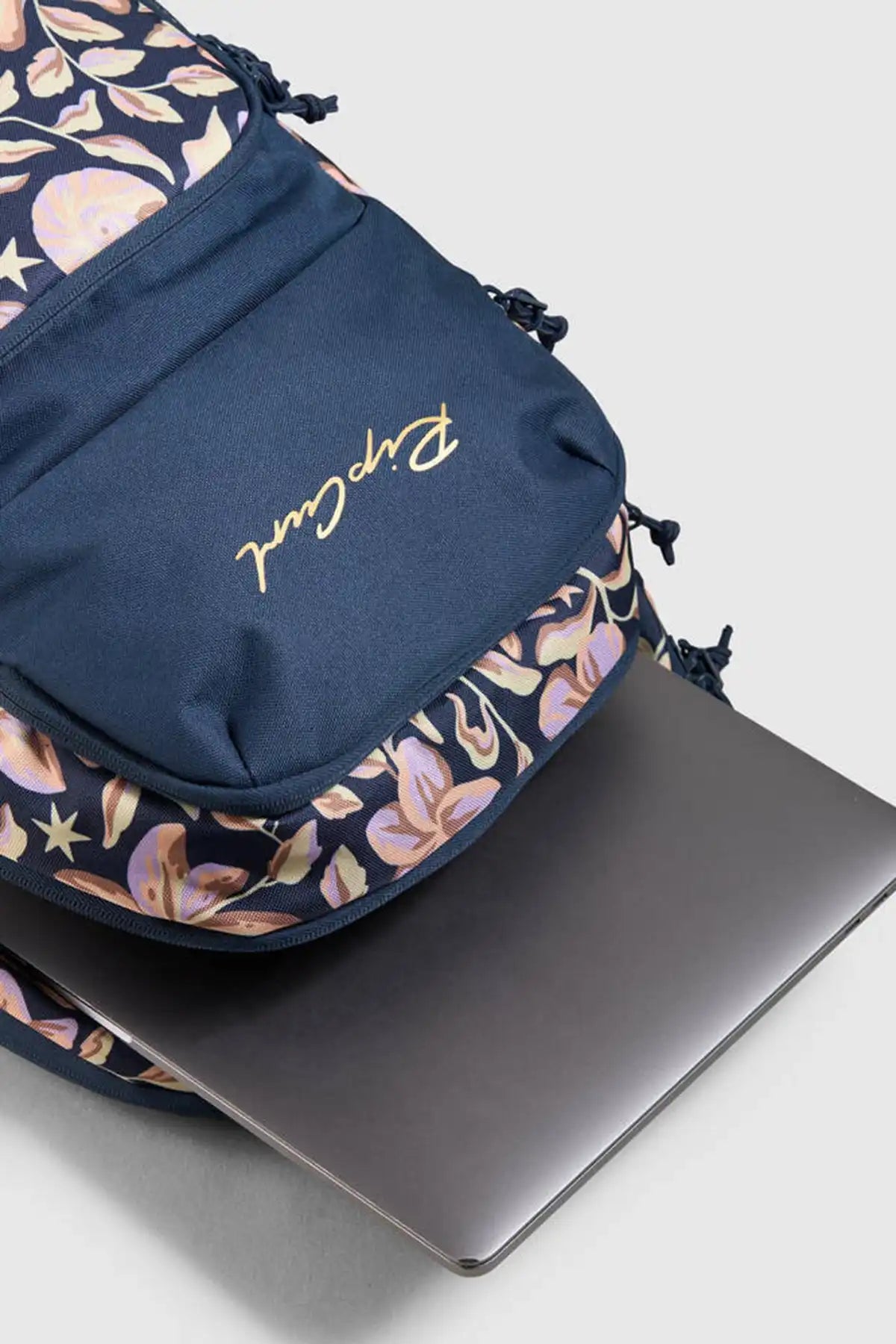 Floral-patterned bag with 'Rip Curl' branding on a light gray background