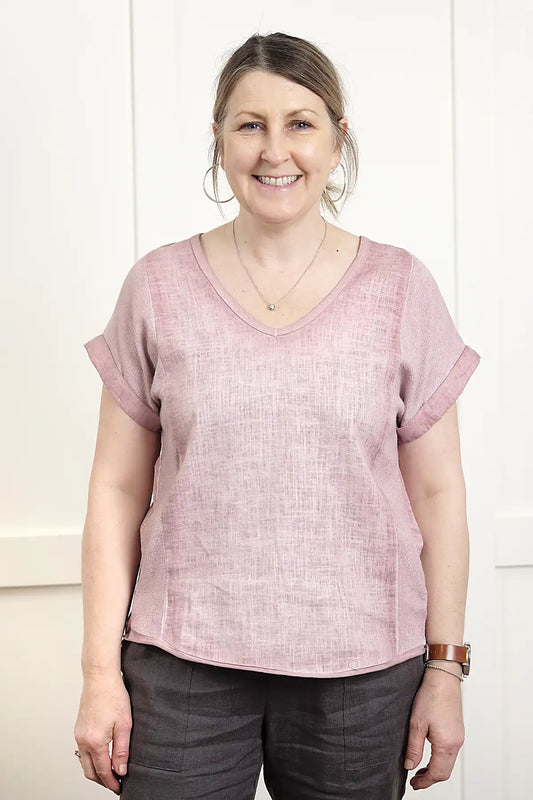 Woman wearing a Rosa V Neck Linen Top in Pink standing against a white wall
