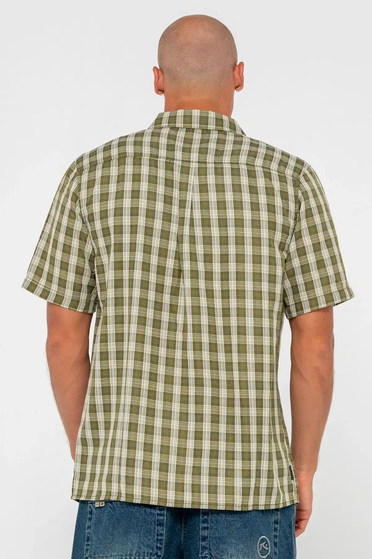 Man wearing a green and white checkered shirt on a white background pictured from behind