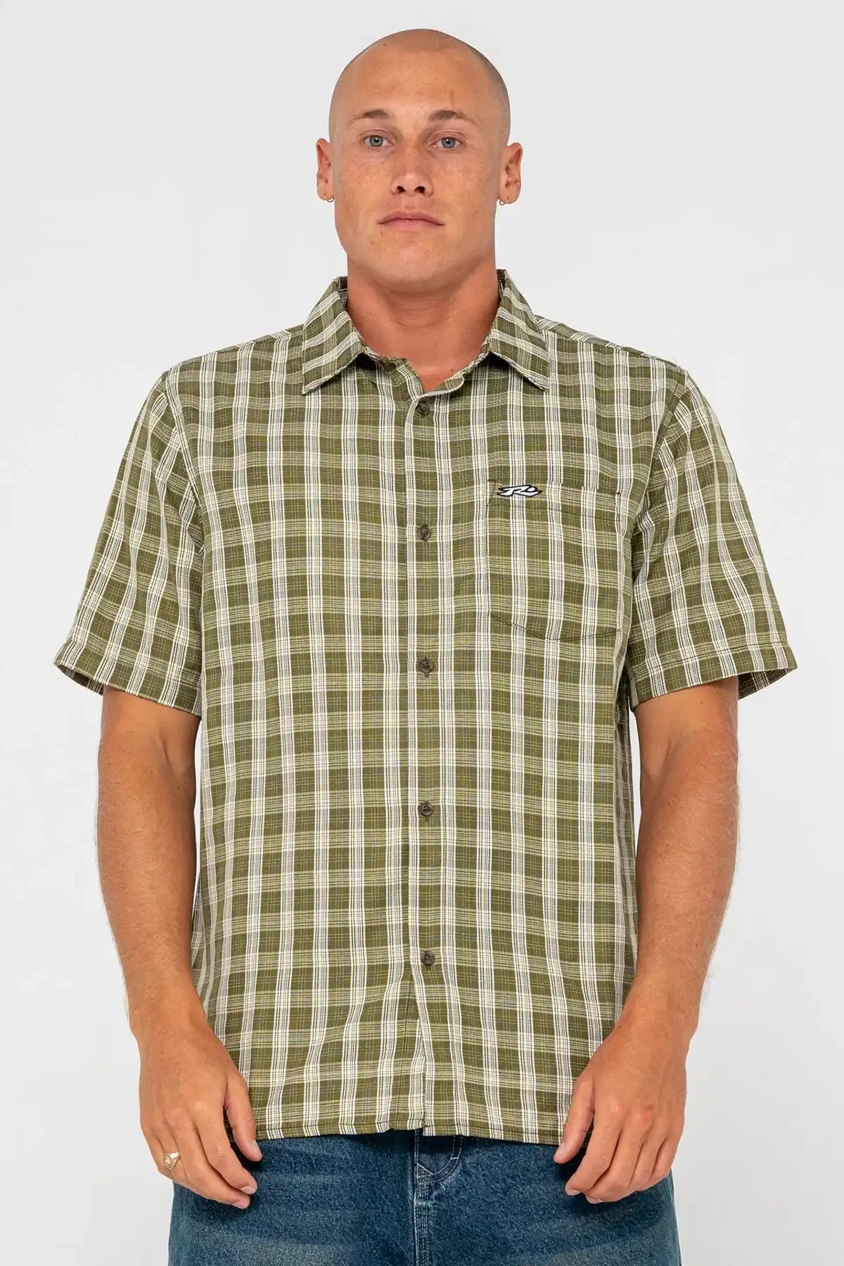 Man wearing a green checkered shirt with a Rusty logo on a white background