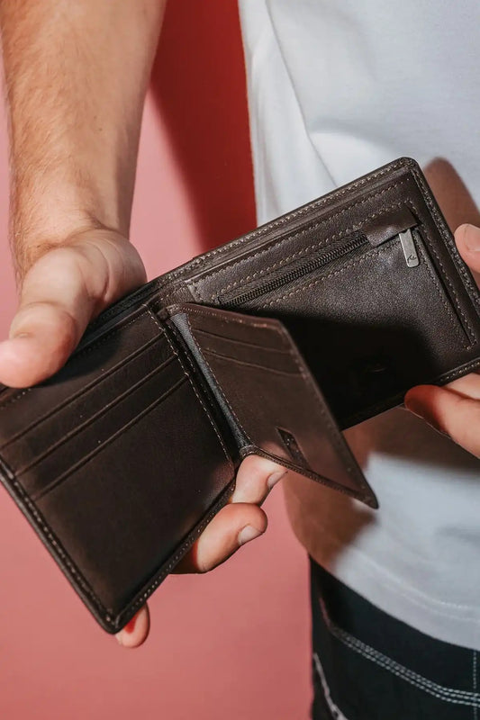 man holding the Rusty High River 2 Leather Coffee Wallet open so you can see the compartments