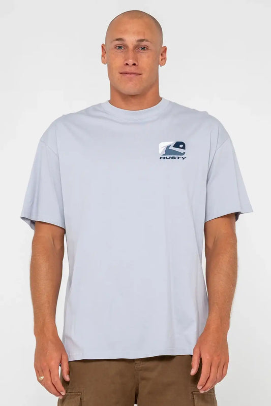 man wearing Rusty Mens Phenom Graphic Tee in Smoke Blue and pinecone shorts on a white background